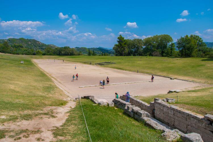 Tourists line up at the start line like the ancients in the Ancient Stadium of Olympia 